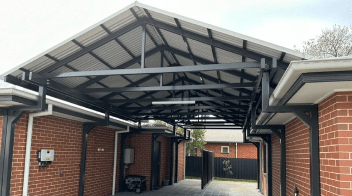 Metal carport structure between two brick buildings